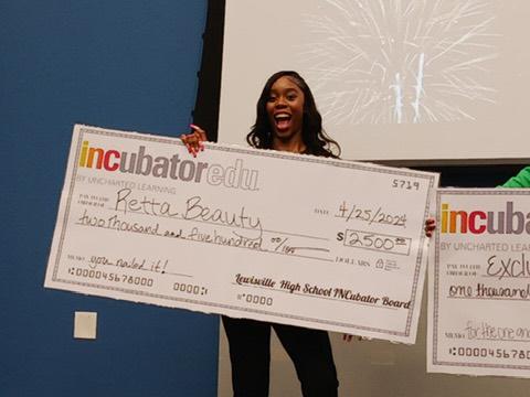 Someone holds an oversized check for Retta Beauty